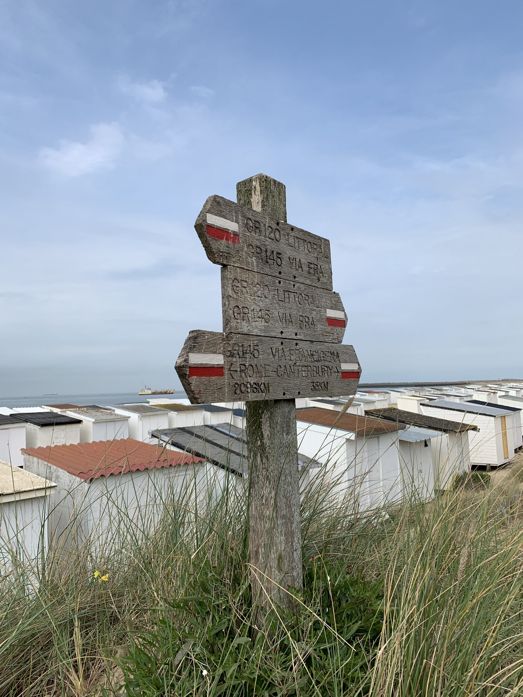 Panneau de balisage GR dans les dunes avec cabines de plage