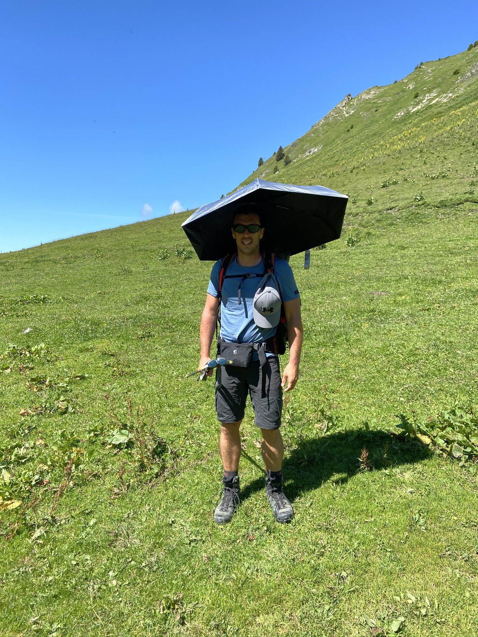 Randonneur avec parapluie de soleil en montagne